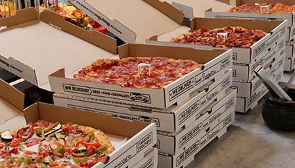 Catering from Smoky Mountain Pizzeria Grill with assorted pizzas lined up on the table.