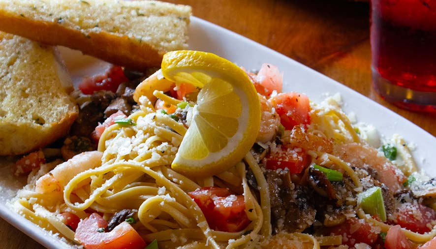 A plate of pasta with shrimp and lemon, served with garlic bread at Smoky Mountain Pizzeria Grill.