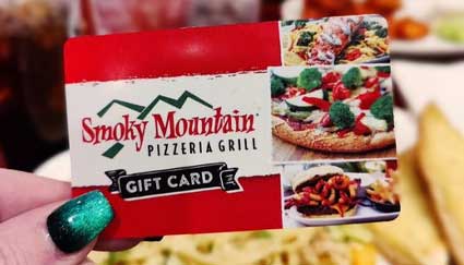 Hand holding a Smoky Mountain Pizzeria Grill gift card at your favorite pizza restaurant.