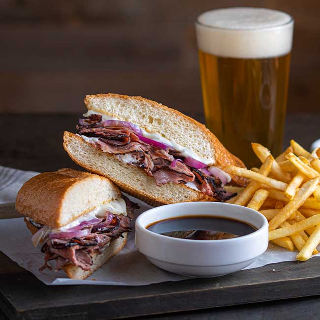 French dip sandwich with fries, au jus, and beer at Smoky Mountain Pizzeria Grill.