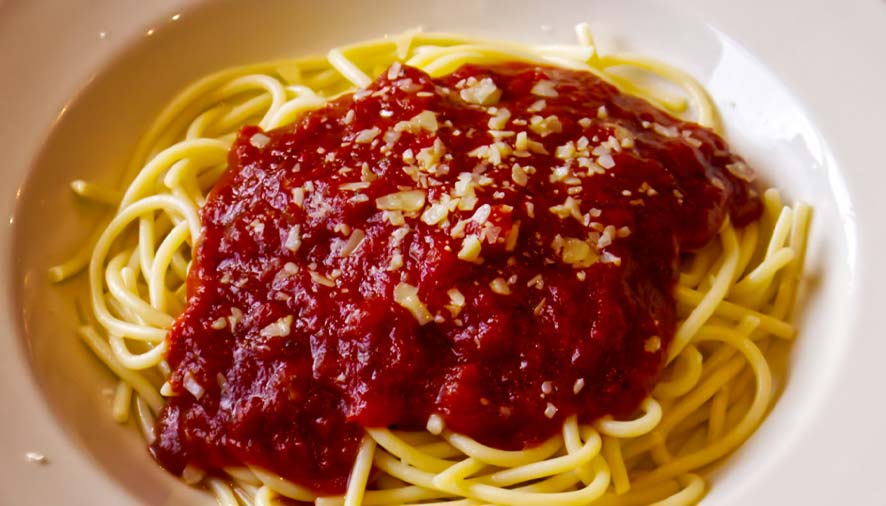 A plate of spaghetti in Boise, Idaho, topped with red tomato sauce and sprinkled with cheese.