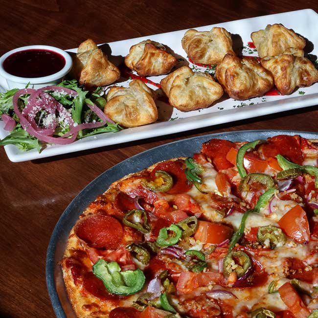 Pizza with vegetables and pepperoni in Meridian Idaho, plus pastries, salad, and dipping sauce.